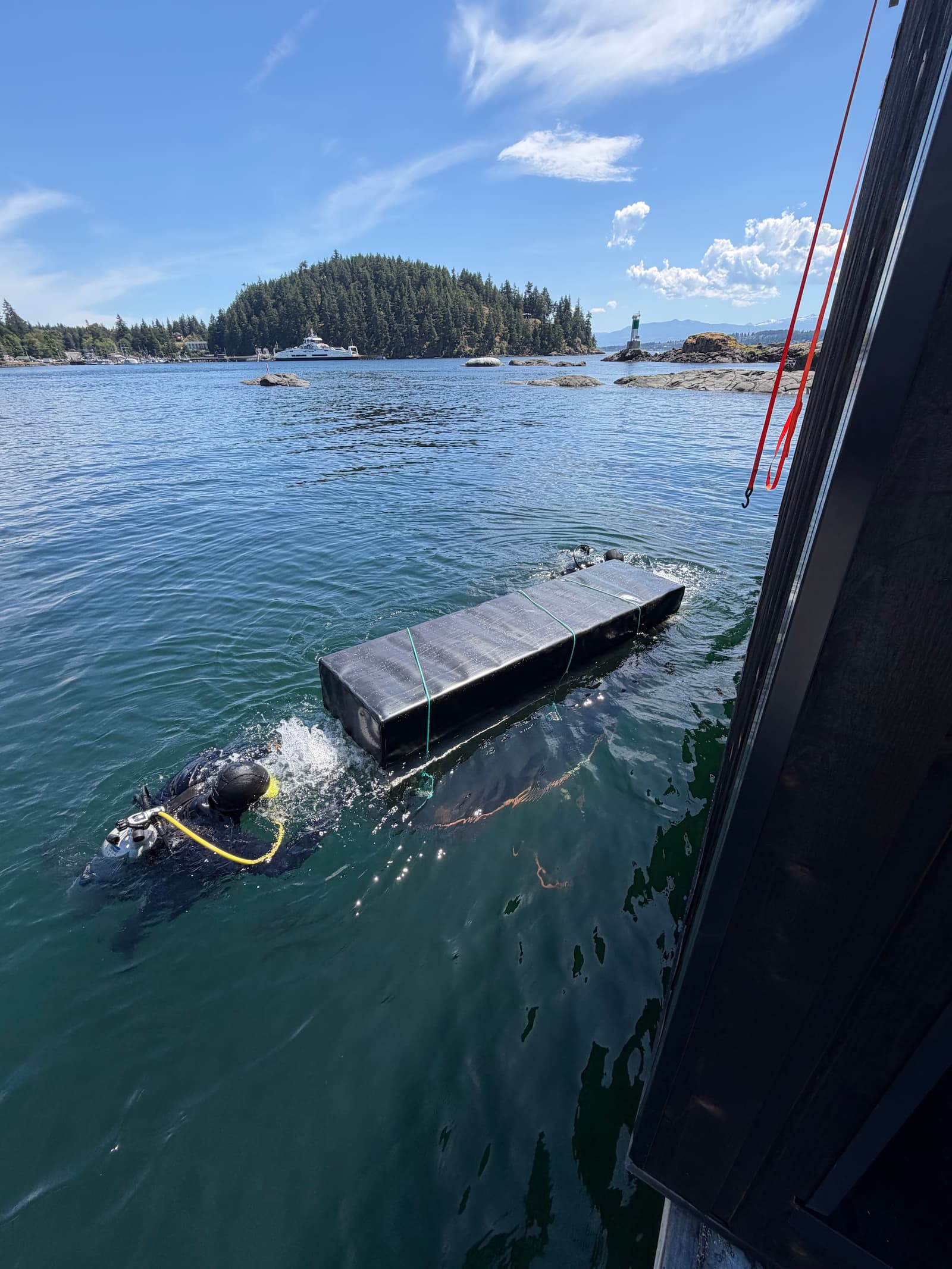 Blacksail Marine diver positioning a floatation billet in the water