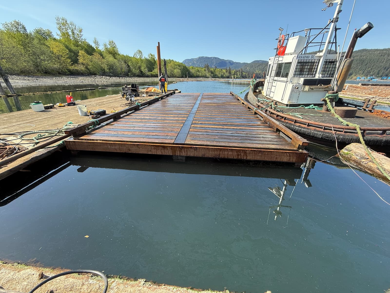 New wooden dock float construction on the water near Campbell River BC, with workboat alongside